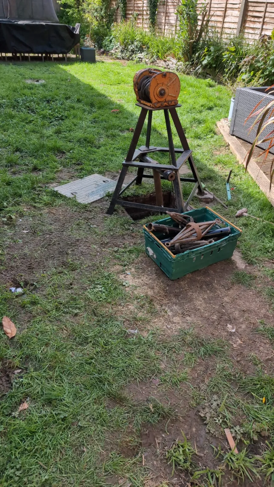 A garden with a wheel and tools in it.