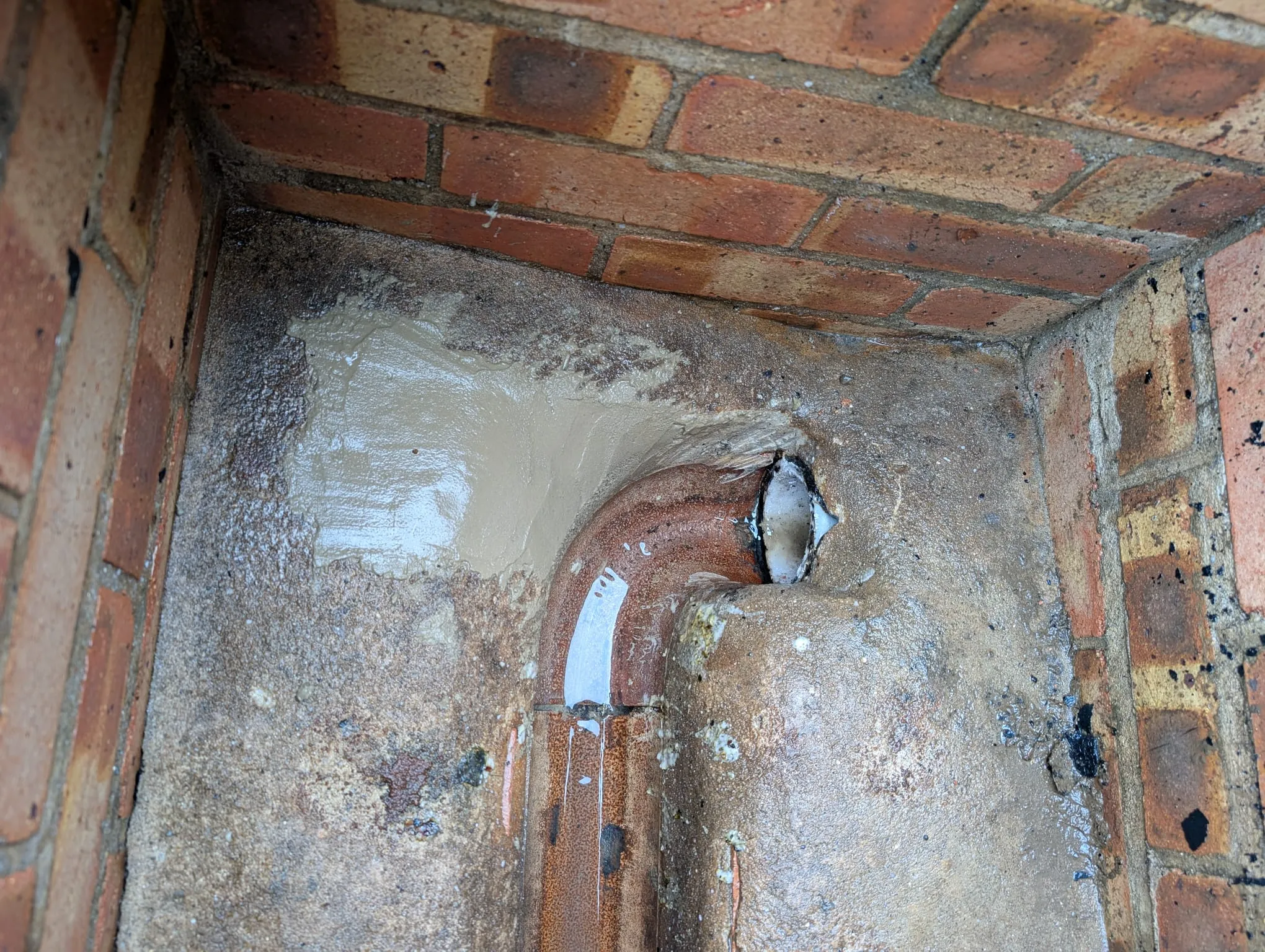 A brick wall with a hole in it.