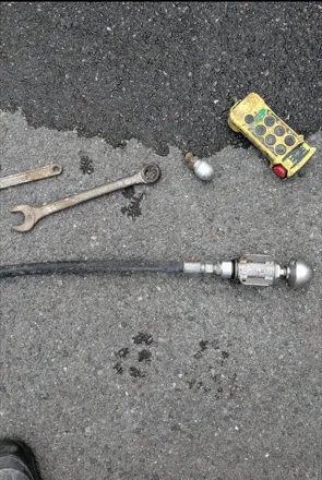 A wrench, screwdriver, and other tools on the ground.