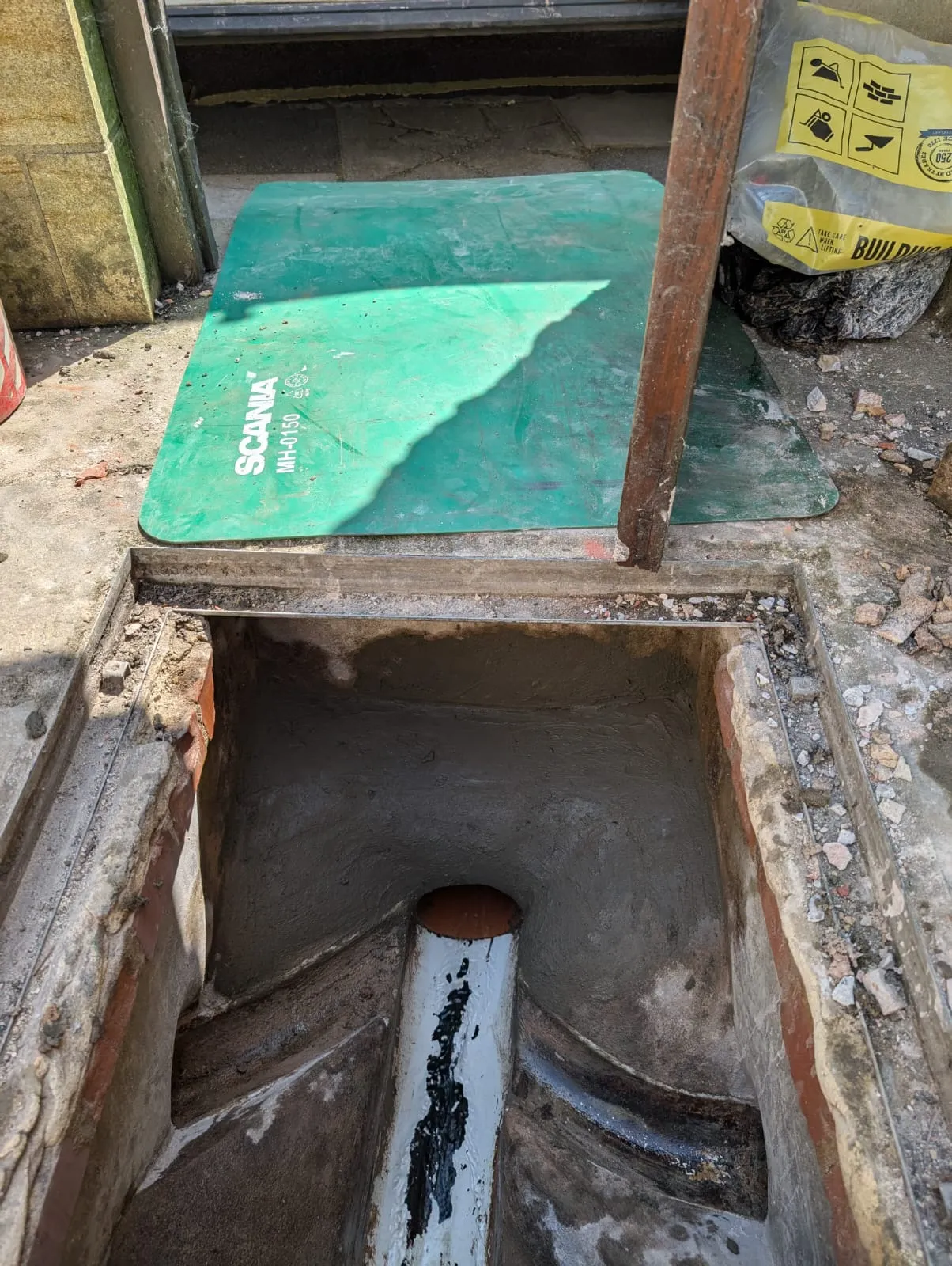 A hole in the ground with a green cover.