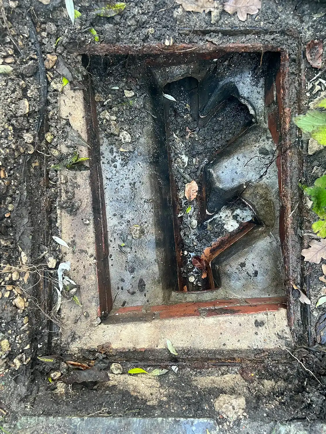a hole in the ground with a broken toilet